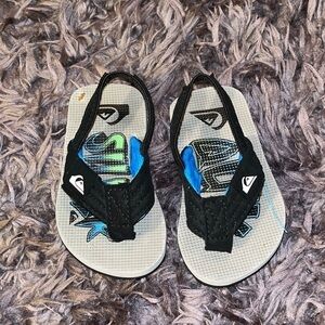 Quicksilver black and blue flip flops for boys.